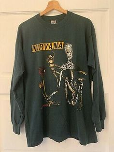 a green nirvana shirt hanging on a door