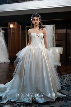 a woman in a wedding dress standing on the floor