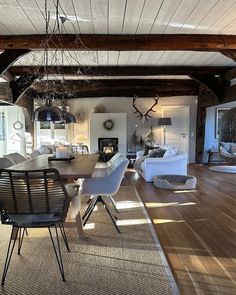 a dining room table and chairs in front of a fireplace