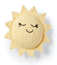 a crocheted sun pillow with eyes closed