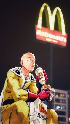 a man sitting on top of a bench next to a mcdonald's sign at night