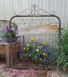 an old metal bed frame with flowers growing in it and a sign that says garden suite