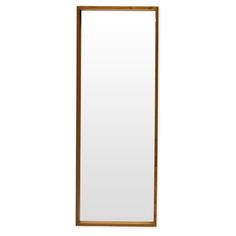 a tall mirror sitting on top of a white wall next to a wooden framed window