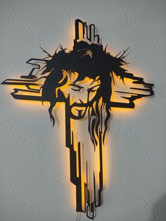 a cross with the face of jesus on it is lit up in yellow and black