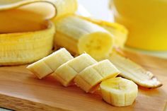 sliced bananas sitting on top of a wooden cutting board