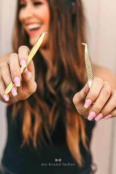 a woman holding two gold colored scissors in her hands