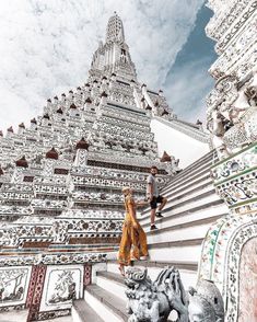 two people are walking up some stairs in front of a building with intricate designs on it