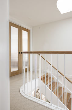 an empty room with stairs leading up to the second floor and another door in the background