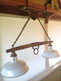 two white lights hanging from a wooden beam