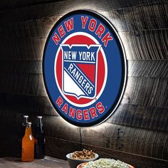 the new york rangers neon sign is next to two bowls of food on a table