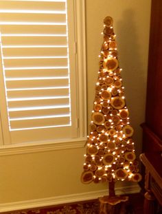 a christmas tree made out of donuts is shown in front of a window with shutters