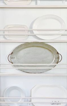 white dishes and plates are stacked on shelves