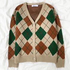 Wear the colors of the forest in this diamond argyle check cardigan with a v-neckline and button up front. 22" across shoulders, 44" chest, 24" length Classic Argyle Pattern Sweater For Fall, Winter Plaid V-neck Cardigan, Classic Plaid Long Sleeve Cardigan, Plaid V-neck Cardigan For Fall, Casual Argyle Pattern Outerwear For Fall, Plaid V-neck Outerwear For Fall, V-neck Plaid Outerwear For Winter, Plaid Cardigan, The Forest