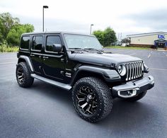 a black jeep parked in a parking lot