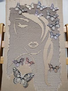 a woman's face is surrounded by butterflies on a piece of cardboard that has been cut into the shape of a woman's head