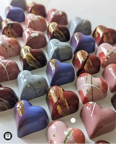 many different colored heart shaped chocolates on a table