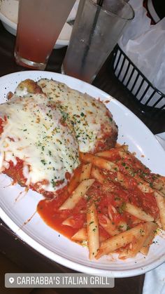 a white plate topped with pasta and meat covered in sauce