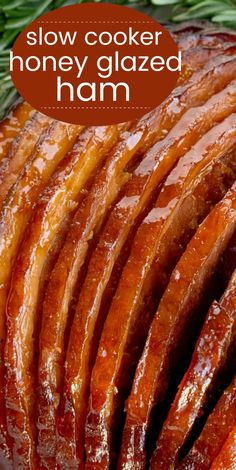 sliced honey glazed ham on a platter with rosemary sprigs in the background