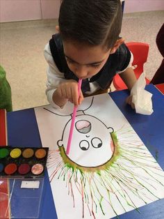 a young boy is painting on paper with colored pencils and crayon pens