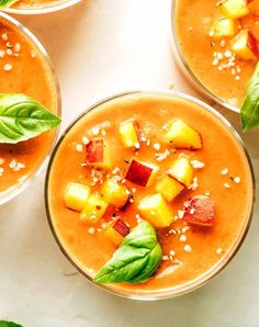 three bowls filled with soup and garnished with green leafy leaves on top