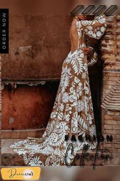 a woman in a brown and white dress leaning against a brick wall with her back to the camera