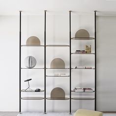 an empty room with shelves and lamps on the wall next to a couch in front of it