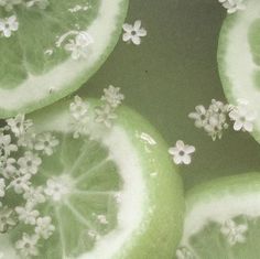 several slices of limes with white flowers on them are shown in close up view