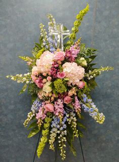 a large bouquet of flowers on display against a blue wall with an arrow in the center