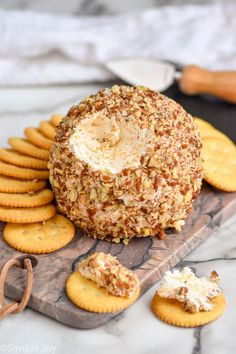 a cheese ball on a cutting board surrounded by crackers