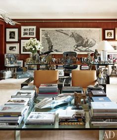 a living room filled with lots of furniture and books on top of a glass table