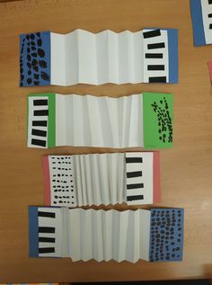 four pieces of paper that have been folded into piano keys and are sitting on a table