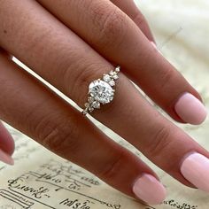 a close up of a person's hand with a diamond ring on top of it