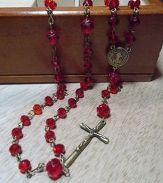 Handmade Rosary with Brass Crucifix and medallion, Czech Preciosa Crystal Beads in Red Ruby & Red Glass Flower Beads. Rose Beads. Please note: All Props, Clothing, Wigs, Mannequin, purses, jewelry boxes, etc. are NOT included with the purchase of this listing. The dollar amount specified for sale, only includes the Rosary that is described above.  Always check the top of my Announcement page for any available coupon codes. If you have a coupon or a gift certificate, the code must be put in the c Red Rosary Beads For Jewelry Making, Vintage Red 8mm Beaded Jewelry, Vintage Red Jewelry With 8mm Beads, Handmade Red Rosary For Jewelry Making, Adjustable Red Beaded Rosary, Red Beaded Rosary With Round Beads, Silver Leaf Bracelet, Handmade Rosary, Shoulder Duster Earrings