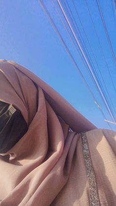 the back end of a woman's head with many wires in the sky behind her