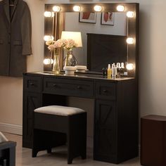 a dressing table with lights on it and a stool in front of the vanity mirror