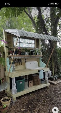 an outdoor kitchen made out of pallets in the woods with lots of potted plants