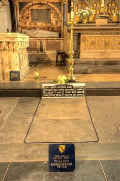 the interior of a church with a plaque on the floor and flowers in front of it