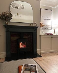 a living room with a fire place in the center and a mirror on the wall