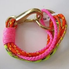 the pink, yellow and green braided bracelet has a metal hook on it's end