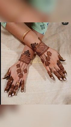 two hands with henna tattoos on them