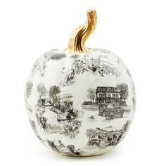 a white pumpkin with black and gold designs on the front, sitting against a white background