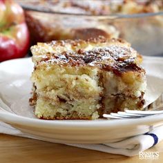 a piece of cake sitting on top of a white plate next to an apple pie