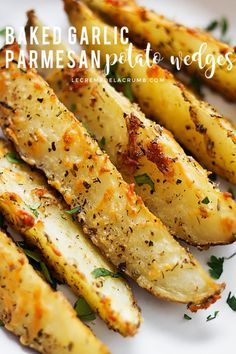 grilled potato wedges on a white plate with parmesan cheese and herbs