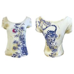 Amazing vintage Roberto Cavalli Spring / Summer 2003 dragon / flower tattoo print short sleeve rayon and elastane t-shirt ! This rare beauty comes from Cavalli’s most famed collections. Features a yellow and tan background with navy blue floral and dragon motifs. Pop of red on two flowers. Gold and silver metallic accents throughout, with gold thread serving as the stitching. Very soft material that stretches to fit. In great condition Made in Italy Model in video is US Size 6, and 5’8 feet tall Approximately Size Small / Medium ( tons of stretch ) Measurements: 32-40 inch bust 28-33 inch waist Read the Vogue review of Cavalli’s Spring/Summer 2003 collection: "These days, Roberto Cavalli, senior rock god of Italian fashion, has to build a stadium to contain the legions of fans who throng t Cotton Short Sleeve Tops With Dragon Print, Dragon Print Clothes, Dragon Flower Tattoo, Jennifer Lopez Concert, Vintage Roberto Cavalli, Dragon Flower, Roberto Cavalli Dress, Dragon Shirt, Embroidered Kimono