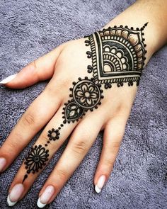 henna tattoo on someone's hand with the word henna written in it