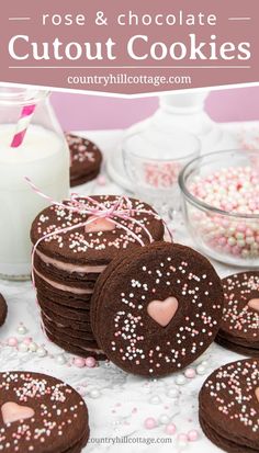 chocolate cookies with pink and white sprinkles next to a glass of milk