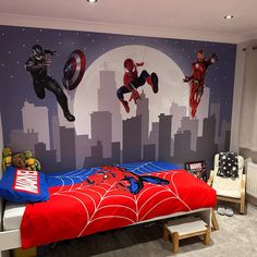 a bedroom with a spiderman themed wall mural