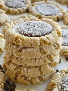 several cookies stacked on top of each other with chocolate chips and powdered sugar in the middle