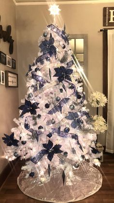 a white christmas tree with blue and silver decorations