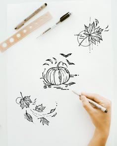 someone is drawing some pumpkins on a piece of paper